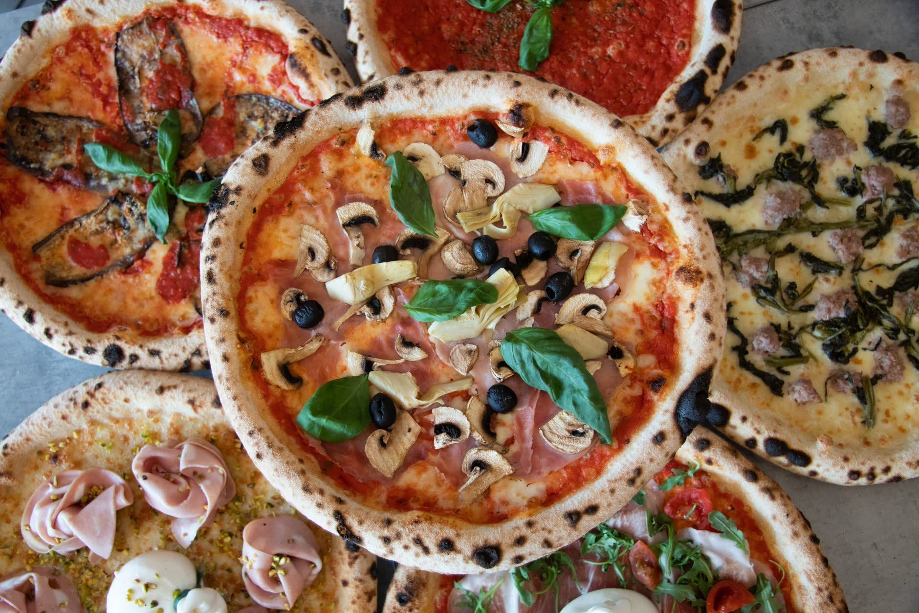 Fette di pizza margherita coperte da pellicola trasparente dentro un contenitore rettangolare in frigorifero