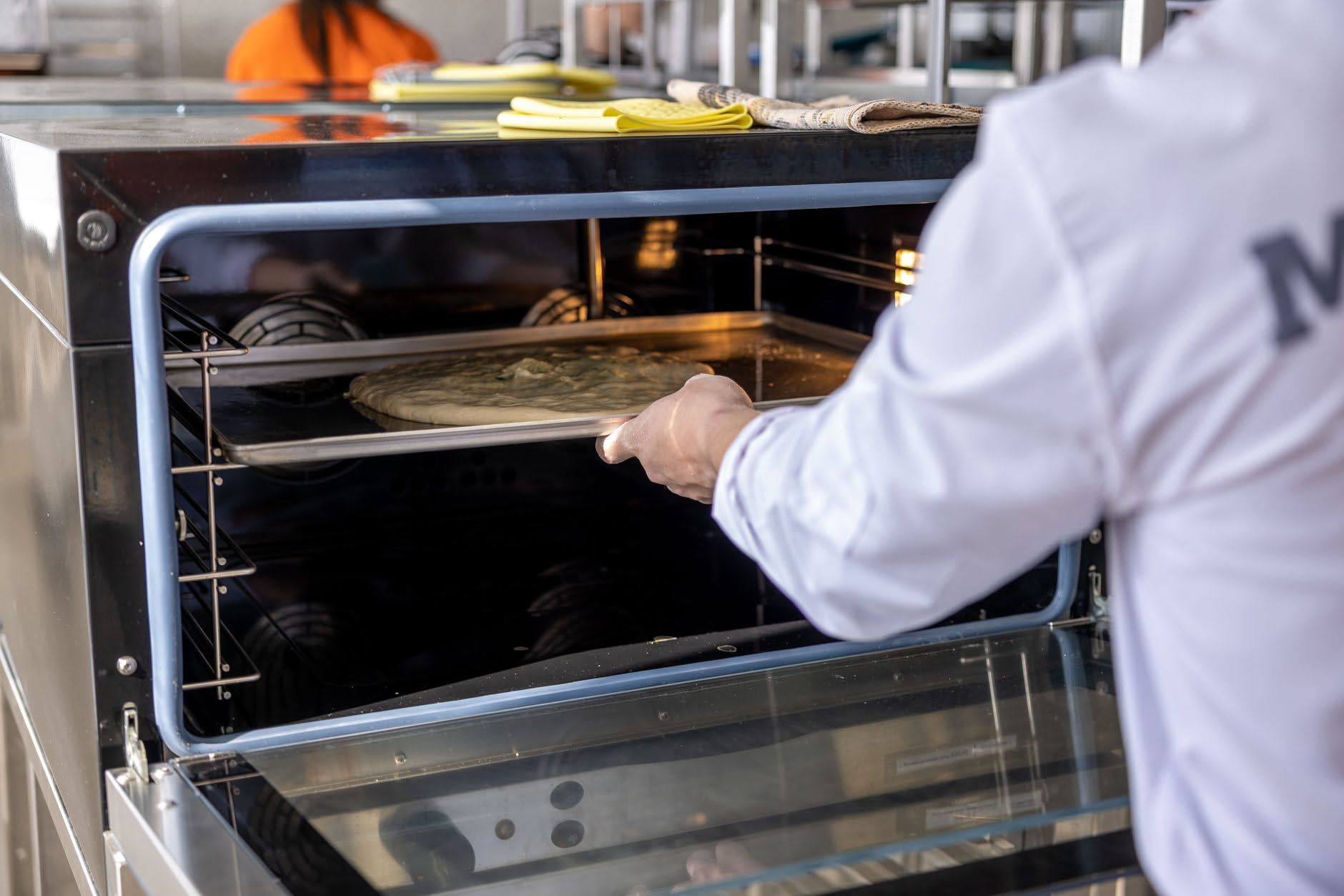 Pizza ai pomodori e basilico appena sfornata da un forno domestico compatto, cornicione gonfio e surface croccante