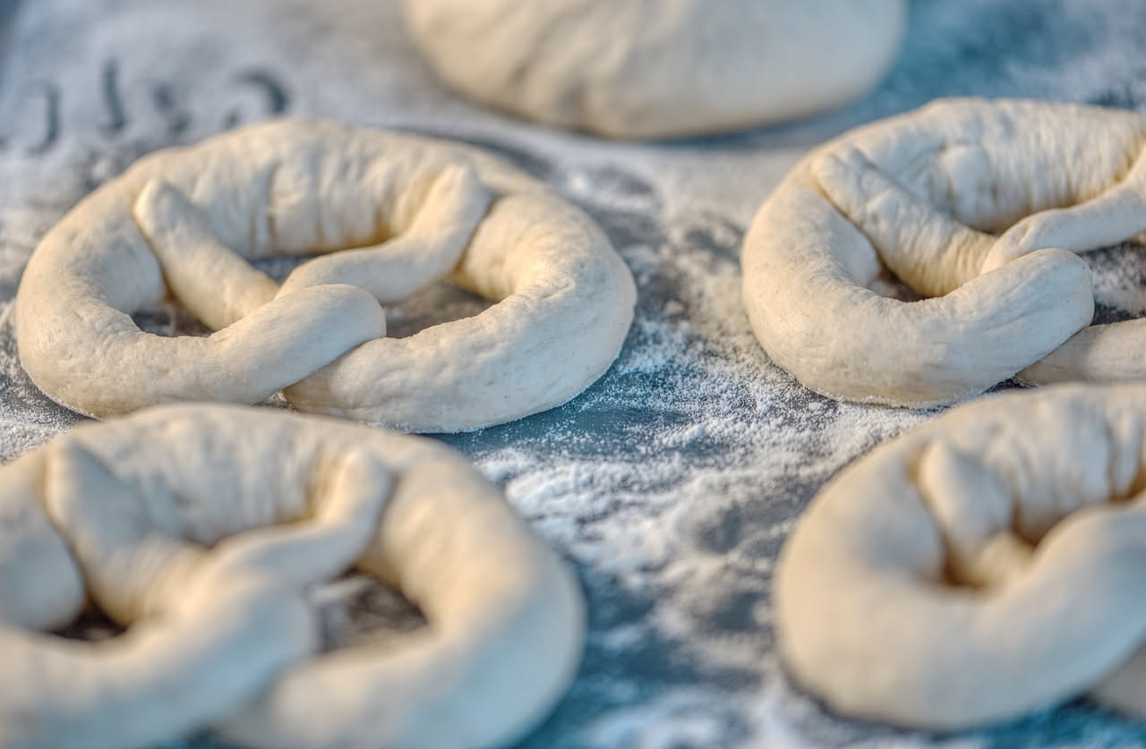 Interno di una cella di lievitazione professionale con impasti in teglia su ripiani, display digitale di temperatura e umidità, pareti isolate bianche