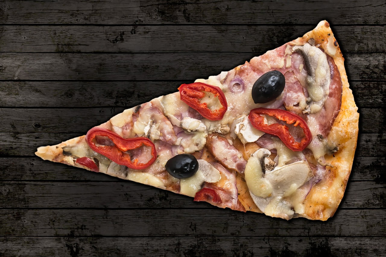 Fetta triangolare di pizza New York con mozzarella bianca filante, sugo di pomodoro rosso vivo e cornicione dorato gonfio, tenuta da una mano, su sfondo di piastrelle bianche