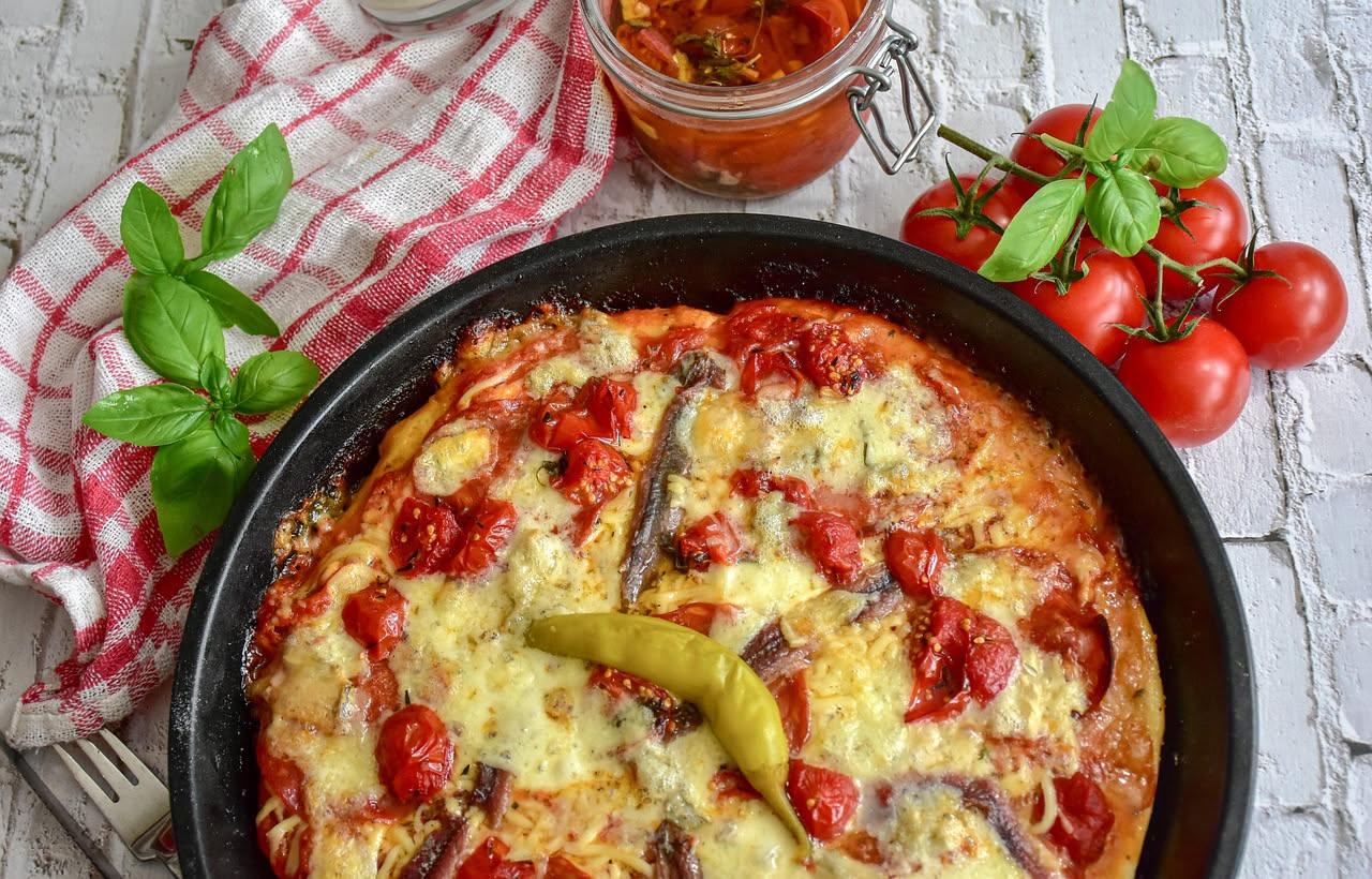 Pizza al padellino torinese in teglia quadrata bassa, tagliata a fette, con impasto dorato e croccante, pomodoro e mozzarella, vista dall'alto
