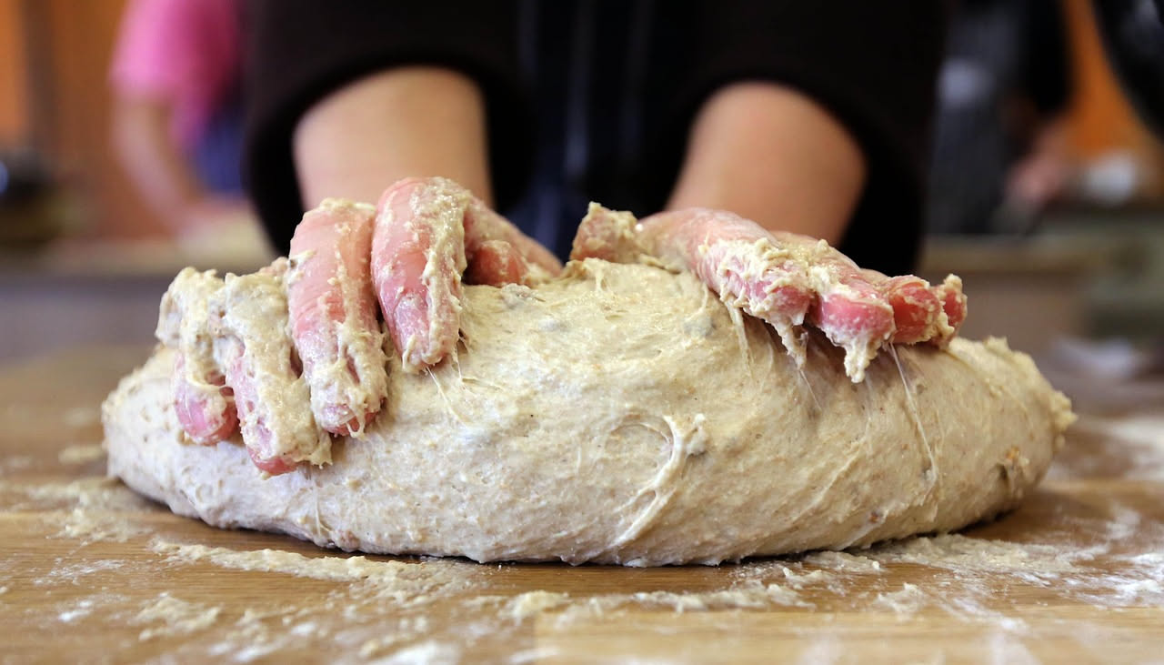 Due mucchi di farina bianca su superficie di marmo: uno compatto e denso, l'altro friabile e leggero, accanto a un cilindro graduato con etichetta W250 e W350