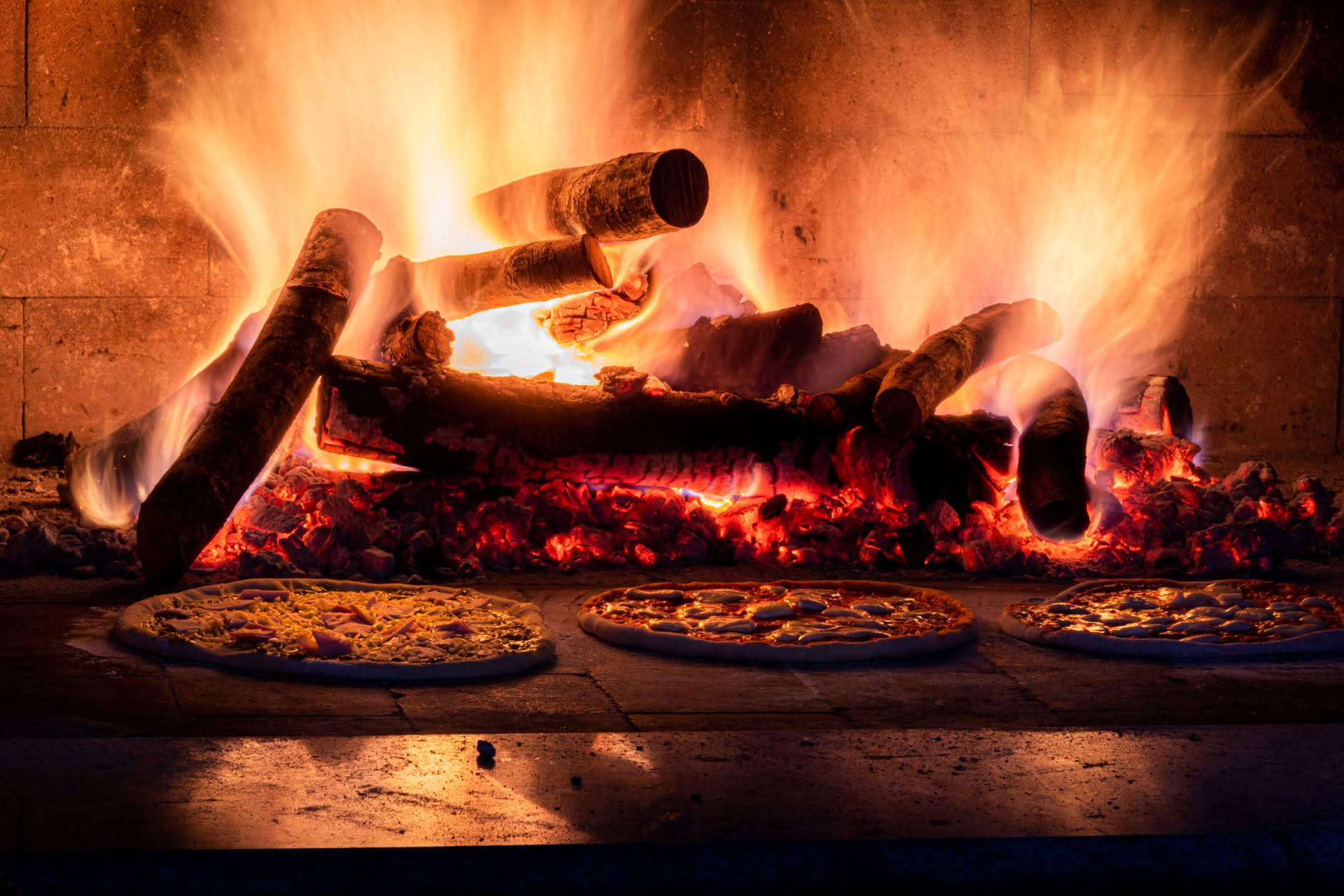 Fetta di pizza al forno su teglia di alluminio, cornicione dorato coperto da un foglio protettivo, interno morbido e condimento fresco
