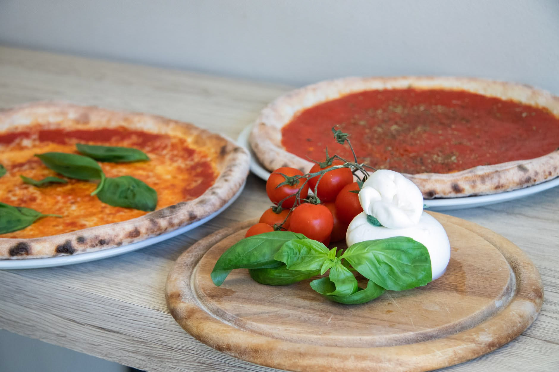 Impasto di pizza appena formato in teglia, con bolle di gas in superficie, pronto per la cottura in forno acceso