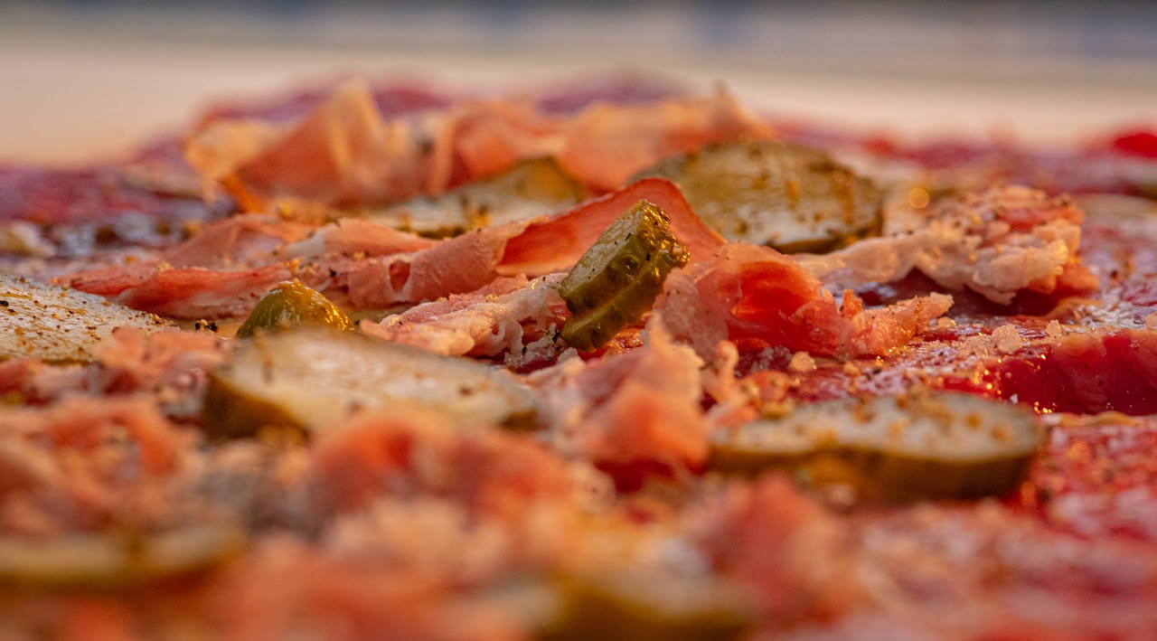 Fetta di pizza napoletana con mozzarella di bufala appena sfornata, filamenti di formaggio ancora caldi sopra il pomodoro rosso, cornicione dorato