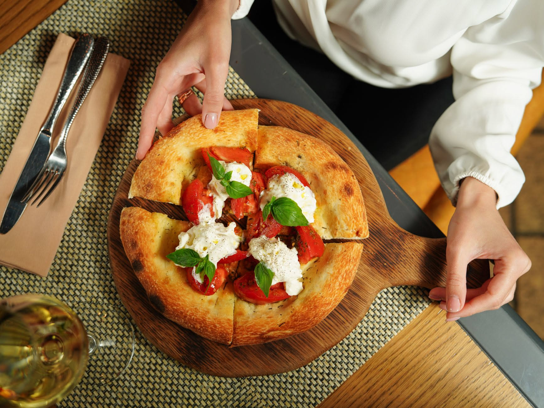 Panetto di impasto di pizza romana in teglia rettangolare, visto dall'alto, su un banco di lavoro infarinato con accanto una bilancia digitale