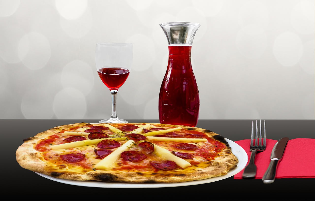 Un grande menù cartaceo aperto su tavolo di legno, con oltre cinquanta varianti di pizza scritte in caratteri piccoli, immagine simbolica di confusione e mancanza di focus