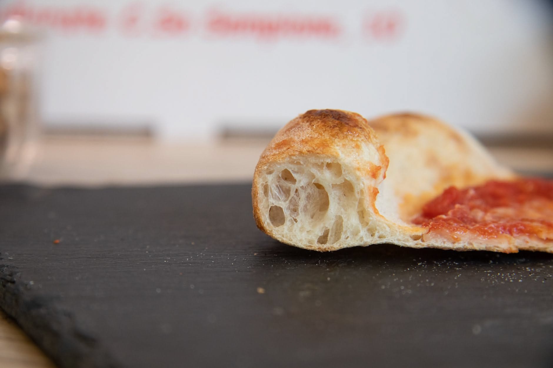 Pezzi di impasto dorati che friggono in olio abbondante dentro una pentola alta, con bollicine vivaci in superficie