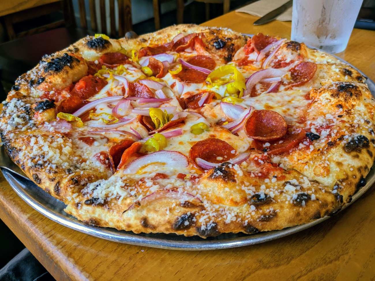 Pizza con salame piccante, cipolla e peperoncini